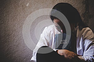 Manos doblada en oración sobre el Sagrada Biblia en iglesia fe 