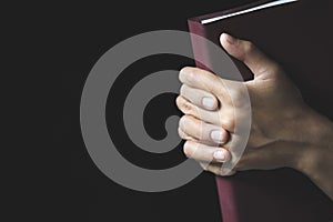 Hands folded in prayer on a Holy Bible  in church concept for faith, spirtuality and religion, Worship, sins and prayer
