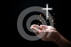 Hands folded in prayer on Holy Bible with cross in church concept for faith, spirituality and religion, Man praying on holy bible