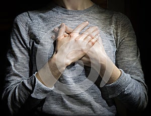 Hands folded in prayer over the heart