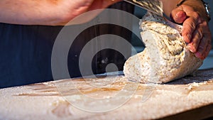 Hands folding and kneading dough