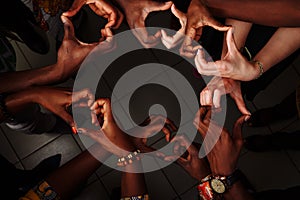 Hands in the form of heart of happy group of multinational African, latin american and european people which stay