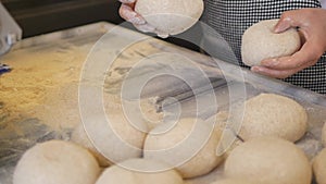 hands form pieces of dough for baking bread and rolls.