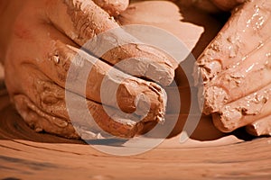 Hands forming clay