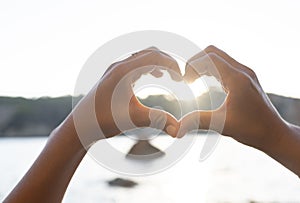 Hands forming a heart on the beach