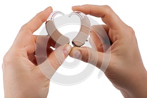 Hands forming a heart shape from hearing aids isolated