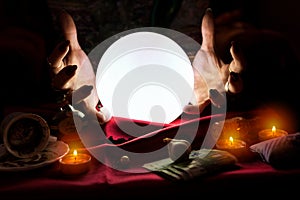 Hands of fortune teller with crystal ball in the middle photo