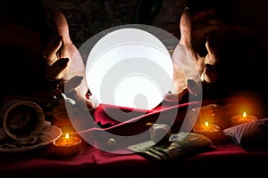 Hands of fortune teller with crystal ball in the middle