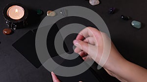 Hands of fortune teller woman make a deal for the future with the help of cards.