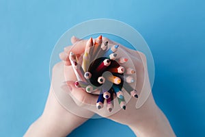 Hands full of bunch colored pencils