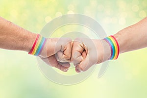 Hands with gay pride wristbands make fist bump