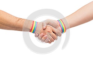 Hands with gay pride wristbands make handshake