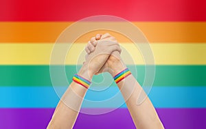 Hands with gay pride wristbands in winning gesture