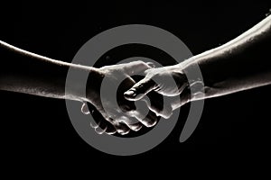 Hands gesturing on black background. Giving a helping hand. Support and help, agreement. Hands of two people of rescue