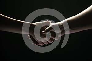 Hands gesturing on black background. Giving a helping hand. Support and help, agreement. Hands of two people of rescue