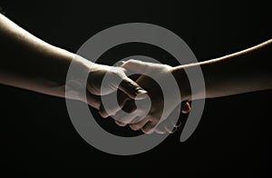 Hands gesturing on black background. Giving a helping hand. Support and help, agreement. Hands of two people of rescue