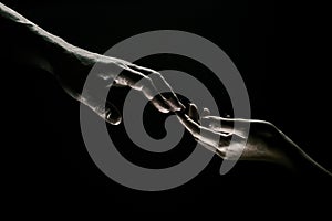 Hands gesturing on black background. Giving a helping hand. Support and help, salvation. Hands of two people at the time