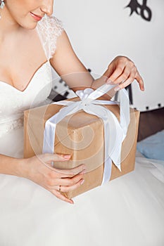 Hands with gift box on the wedding celebration. Studio portraits of beautiful bride with gift .Bride Holding Gift . Christmas