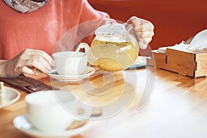 Hands of a girl in a cafe and drinking hot herbal tea. fragrant