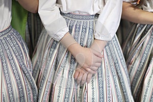 The hands of a girl in an ethnographic costume