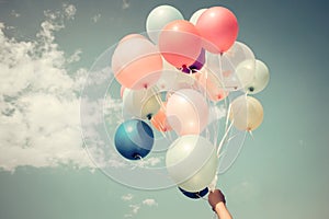 Hands of girl holding multicolored balloons