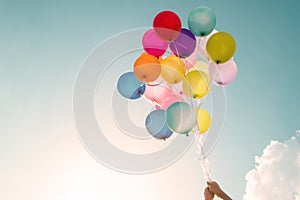 Hands of girl holding multicolored balloons