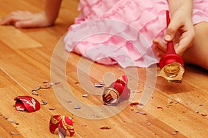 Hands of girl picking up smithereens of Christmas ball photo