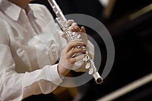 Hands of the girl playing a flute