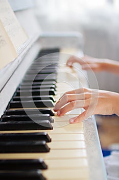 Hands of a girl playing the piano