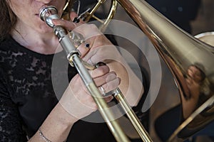 Hands of a girl playing the trombone