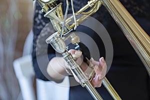 Hands of a girl playing the trombone