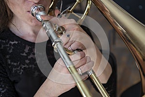 Hands of a girl playing the trombone