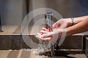 Hands of a girl with a ring washing in a bathroom