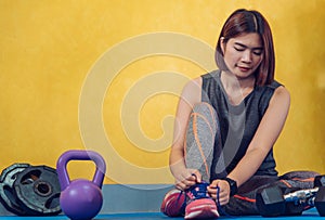 The hands of a girl`s shoelace and sneakers in the gym are ready