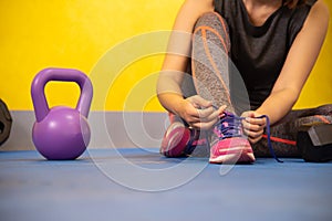 The hands of a girl`s shoelace and sneakers in the gym are ready