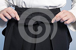 Hands of a girl tie a hakama