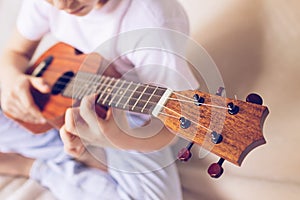 Hands girls play the guitar. A child learns to play the guitar. Selective focus. Close-up. The concept of music and art