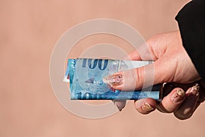 Hands giving money like a bribe or tips. Holding  swiss franc banknote on a blurred background, CHF currency