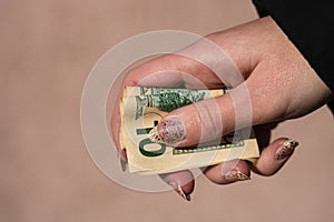 Hands giving money like a bribe or tips. Holding US dollars banknotes on a blurred background, US currency