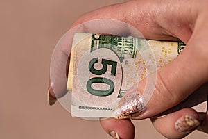 Hands giving money like a bribe or tips. Holding US dollars banknotes on a blurred background, US currency