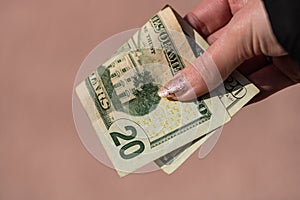 Hands giving money like a bribe or tips. Holding US dollars banknotes on a blurred background, US currency