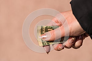 Hands giving money like a bribe or tips. Holding US dollars banknotes on a blurred background, US currency