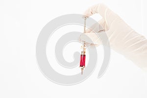 Hands with a glass syringe in gloves