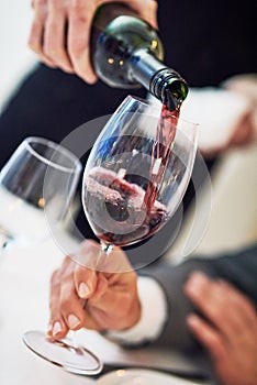 Hands, glass and waiter pouring wine for serving, catering or working at restaurant for customer service. Hand of diner