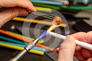 Hands of the glassmaker, shaping figurines from murano glass.