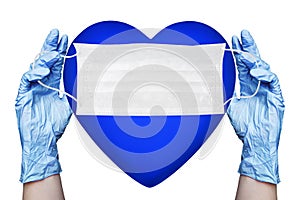 Hands in gloves hold medical face mask and blue heart white background isolated close up, love life safety symbol, pritection