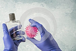 Hands in gloves holding cologne bottle to disinfection virus