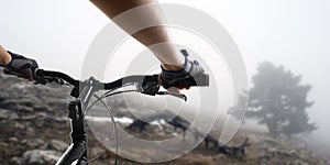 Hands in gloves holding handlebar of a bicycle