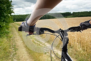 Hands in gloves holding handlebar of a bicycle. Mountain Bike cyclist riding single track. Healthy lifestyle active