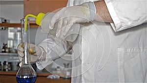 Hands in Gloves of the Lab Technician Dilution Blue Liquids